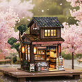 Japanese grocery store book nook kit glowing under cherry blossoms - finished zakoya diorama