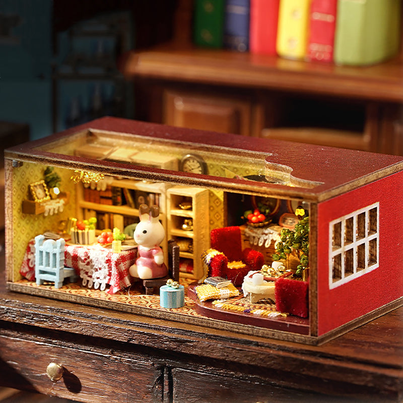 Miniature dollhouse with red roof displayed on wooden table